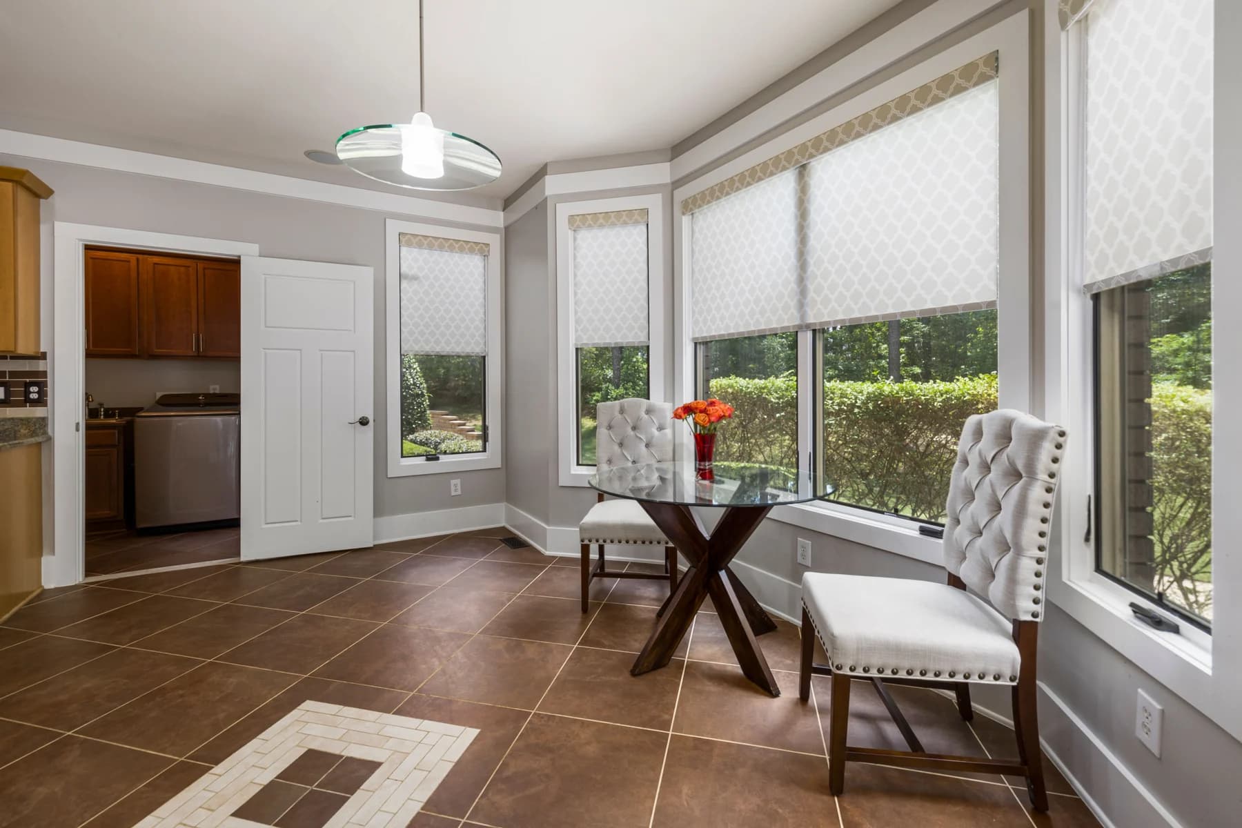Sunlit dining room with patterned roller shades